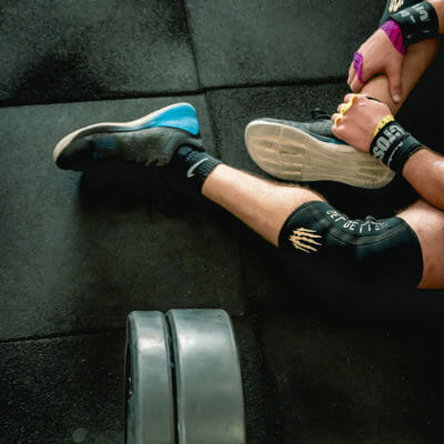 Man's legs resting on a gym floor